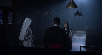 Movie still from “Nightmare Cinema” (2018), directed by Alejandro Brugués – A man and a woman are standing in a dark room; Medium shot, Over the shoulder angle