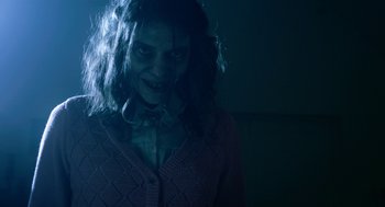 Movie still from “Nightmare Cinema” (2018), directed by Alejandro Brugués – A woman in a purple sweater is looking to her left; Close Up shot, Over the shoulder angle