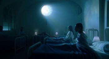 Movie still from “Nightmare Cinema” (2018), directed by Alejandro Brugués – Two people sitting on a bed in a dark room; Wide shot, Low angle