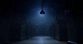 Movie still from “Nightmare Cinema” (2018), directed by Alejandro Brugués – A light hanging from the ceiling in a dark room; Extreme Wide shot, Low angle