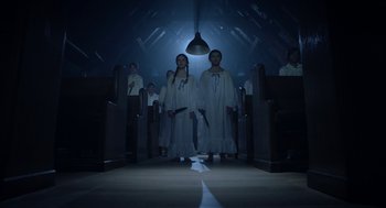 Movie still from “Nightmare Cinema” (2018), directed by Alejandro Brugués – A group of people standing in a dark room; Wide shot, Low angle