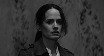 Movie still from “Nightmare Cinema” (2018), directed by Alejandro Brugués – Black and white photograph of a woman in a trench coat; Close Up shot, Low angle