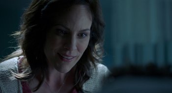 Movie still from “Nightmare Cinema” (2018), directed by Alejandro Brugués – A person smiling at the camera; Close Up shot, Over the shoulder angle