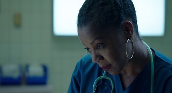 Movie still from “Nightmare Cinema” (2018), directed by Alejandro Brugués – A woman in a blue lab coat with a stethoscope around her neck; Close Up shot, Low angle