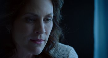 Movie still from “Nightmare Cinema” (2018), directed by Alejandro Brugués – A woman's face in a dark room; Close Up shot, Low angle