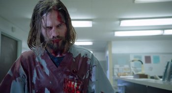 Movie still from “Nightmare Cinema” (2018), directed by Alejandro Brugués – A man with blood on his face is standing in a hospital room; Medium shot, Low angle