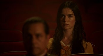 Movie still from “Nightmare Cinema” (2018), directed by Alejandro Brugués – A woman sitting in front of a man in front of a red wall; Close Up shot, Over the shoulder angle