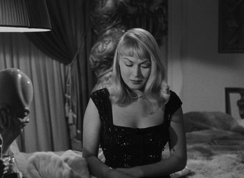Movie still from “Nights of Cabiria” (1957), directed by Federico Fellini – A black and white photo of a woman sitting on a bed; Close Up shot, High angle