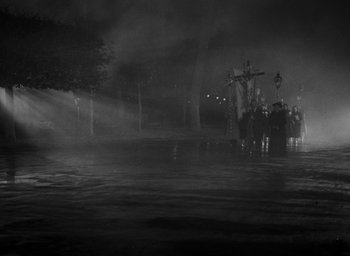 Movie still from “Nights of Cabiria” (1957), directed by Federico Fellini – A group of people standing on a street at night; Extreme Wide shot, High angle