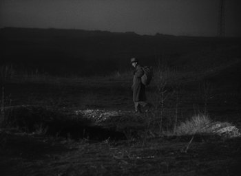 Movie still from “Nights of Cabiria” (1957), directed by Federico Fellini – A man walking through a field at night; Extreme Wide shot, High angle