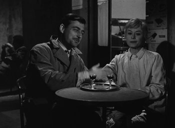 Movie still from “Nights of Cabiria” (1957), directed by Federico Fellini – A man and a woman sitting in front of a wine glass; Medium shot, Over the shoulder angle