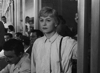 Movie still from “Nights of Cabiria” (1957), directed by Federico Fellini – Black and white photograph of a woman on a train; Medium shot, Over the shoulder angle