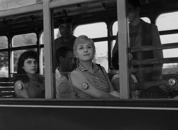Movie still from “Nights of Cabiria” (1957), directed by Federico Fellini – A group of people riding on the back of a bus; Medium shot, Low angle