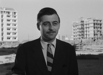 Movie still from “Nights of Cabiria” (1957), directed by Federico Fellini – Black and white photograph of a man wearing a suit and tie; Close Up shot, Low angle