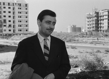 Movie still from “Nights of Cabiria” (1957), directed by Federico Fellini – Black and white photograph of a man wearing a suit and tie; Medium shot, Low angle