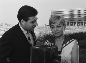 Movie still from “Nights of Cabiria” (1957), directed by Federico Fellini – A man and a woman looking at a piece of metal; Medium shot, Low angle