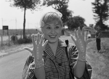 Movie still from “Nights of Cabiria” (1957), directed by Federico Fellini – A black and white photo of a woman wearing gloves; Close Up shot, Low angle