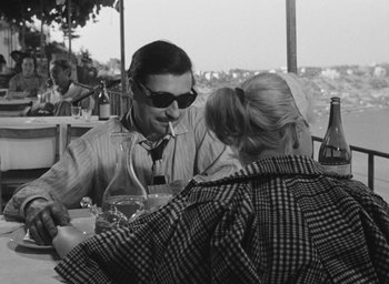 Movie still from “Nights of Cabiria” (1957), directed by Federico Fellini – A black and white photo of a man and a woman at an outdoor restaurant; Medium shot, Over the shoulder angle