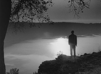 Movie still from “Nights of Cabiria” (1957), directed by Federico Fellini – A man standing on top of a cliff looking at the water; Extreme Wide shot, Low angle