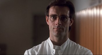 A person wearing glasses and a white shirt