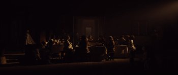 Movie still from “Nightwatching” (2007), directed by Peter Greenaway – A group of people sitting at a table in a dark room; Extreme Wide shot, High angle