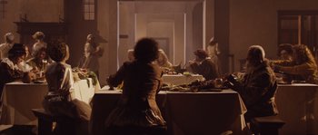 Movie still from “Nightwatching” (2007), directed by Peter Greenaway – A group of people sitting at a table with food on top of it; Wide shot, High angle