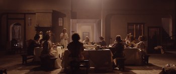 A group of people sitting around a table with food on top of it