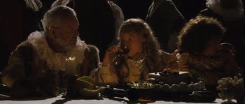 Movie still from “Nightwatching” (2007), directed by Peter Greenaway – A young girl drinking a glass of wine at a dinner table; Medium shot, Over the shoulder angle