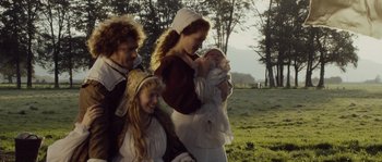 Movie still from “Nightwatching” (2007), directed by Peter Greenaway – A group of people standing in a field holding a baby; Medium shot, Low angle