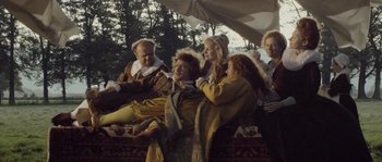 Movie still from “Nightwatching” (2007), directed by Peter Greenaway – A group of people sitting on top of a couch; Wide shot, Low angle