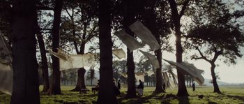 Movie still from “Nightwatching” (2007), directed by Peter Greenaway – A group of people sitting on a bench in a park; Extreme Wide shot, Low angle
