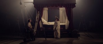 Movie still from “Nightwatching” (2007), directed by Peter Greenaway – Two children dressed as angels standing in front of a bed; Wide shot, High angle