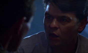 Movie still from “Nil by Mouth” (1997), directed by Gary Oldman – A man is talking to another man in a room; Close Up shot, Over the shoulder angle