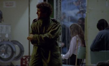 Movie still from “Nil by Mouth” (1997), directed by Gary Oldman – A man standing next to a woman in a green coat; Medium shot, Low angle
