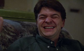 Movie still from “Nil by Mouth” (1997), directed by Gary Oldman – A person smiling with his mouth open; Close Up shot, Low angle
