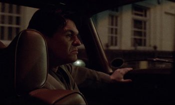 Movie still from “Nil by Mouth” (1997), directed by Gary Oldman – A man sitting in the driver's seat of a car at night; Close Up shot, Low angle