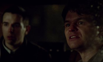 Movie still from “Nil by Mouth” (1997), directed by Gary Oldman – A man in a dark room looking at another man in a dark room; Close Up shot, Over the shoulder angle