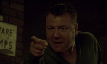 Movie still from “Nil by Mouth” (1997), directed by Gary Oldman – A person holding something in his hand; Close Up shot, Low angle