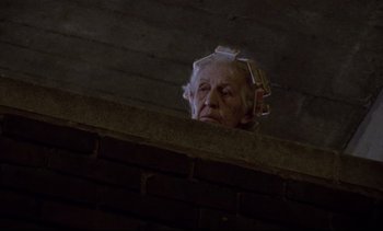 Movie still from “Nil by Mouth” (1997), directed by Gary Oldman – An old woman with a bunch of papers on her head; Close Up shot, Low angle