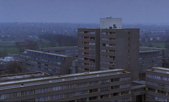 Movie still from “Nil by Mouth” (1997), directed by Gary Oldman – An aerial view of a city with many tall buildings; Extreme Wide shot, High angle