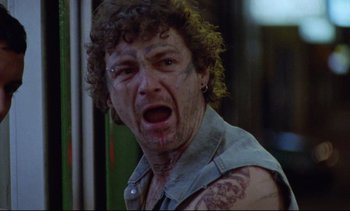 Movie still from “Nil by Mouth” (1997), directed by Gary Oldman – A person with a tattoo on his face; Close Up shot, Low angle
