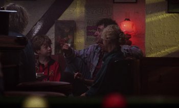 Movie still from “Nil by Mouth” (1997), directed by Gary Oldman – A group of people sitting around a table; Medium shot, Over the shoulder angle