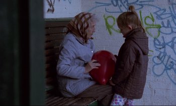 Movie still from “Nil by Mouth” (1997), directed by Gary Oldman – An older woman sitting on top of a bench next to a young girl; Wide shot, Low angle