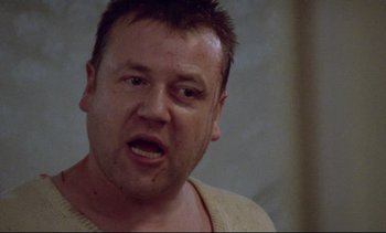 Movie still from “Nil by Mouth” (1997), directed by Gary Oldman – A person wearing a sweater; Close Up shot, Low angle