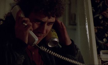 Movie still from “Nil by Mouth” (1997), directed by Gary Oldman – A man holding a phone up to his ear; Close Up shot, Low angle