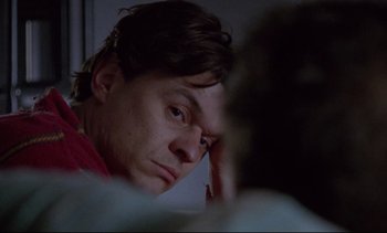 Movie still from “Nil by Mouth” (1997), directed by Gary Oldman – A person with his hand on his forehead; Close Up shot, Low angle