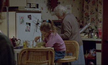 Movie still from “Nil by Mouth” (1997), directed by Gary Oldman – An older woman and a little girl are eating soup; Medium shot, High angle