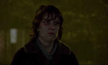 Movie still from “Nil by Mouth” (1997), directed by Gary Oldman – A woman in a brown jacket is looking to her left; Close Up shot, Low angle