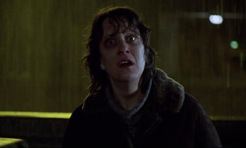 Movie still from “Nil by Mouth” (1997), directed by Gary Oldman – A woman in a brown jacket is looking at the camera; Close Up shot, Low angle