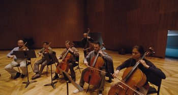 Movie still from “Nimic” (2019), directed by Yorgos Lanthimos – A group of men sitting in a room playing musical instruments; Wide shot, High angle